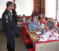 A police officer is serving food to people.